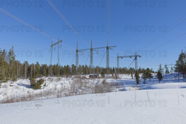 High-voltage power lines in sunny winter weather with snow on the ground, Loviisa, Finland