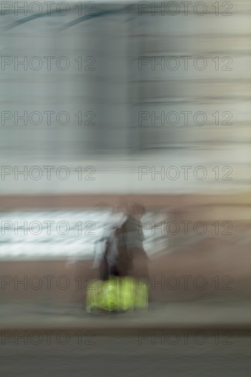 Abstract of a woman walking in front of a building captured using ICM intentional camera movement technique, Helsinki, Finland