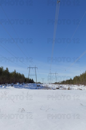 High-voltage power lines in sunny winter weather with snow on the ground, Loviisa, Finland