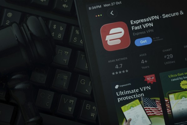 Dhaka, Bangladesh- 28 Oct 2025: An iPad displaying the ExpressVPN app against a judge's gavel and dark keyboard background