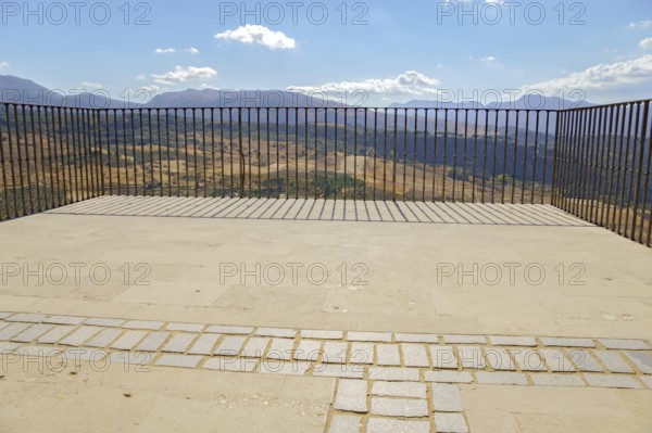 Ronda, malaga, spain Empty outdoor viewpoint balcony offering panoramic summer views of ronda's dry landscape and distant mountains on a sunny day