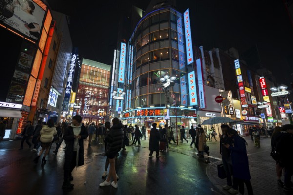 Busy pedestrian zone with many shopping centers and stores, illuminated with lots of neon signs at night, Shibuya, Udagawacho, Tokyo, Japan