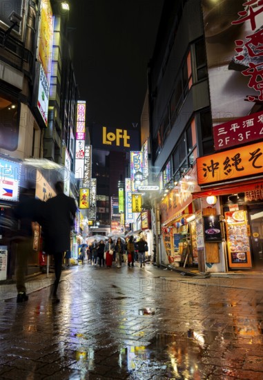 Busy pedestrian zone with many shopping centers and stores, illuminated with lots of neon signs at night, Shibuya, Udagawacho, Tokyo, Japan
