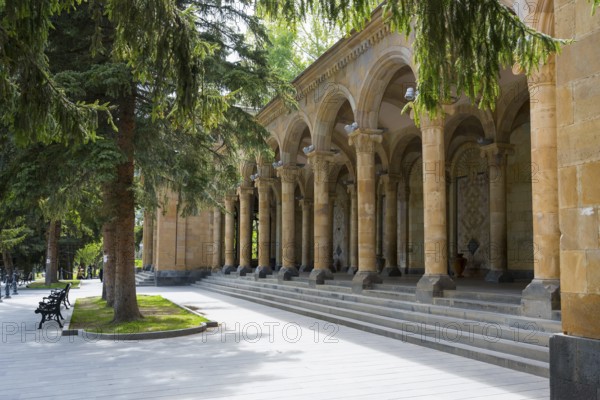 Arch making in a park with stone arches and tall trees in sunny weather, Mineral Water Gallery in Jermuk, Jermuk, health resort, Vayots Dzor province, Armenia