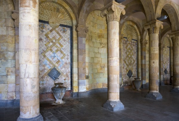 Column with mosaic walls and reliefs surrounded by stone arches that create an ancient atmosphere, Mineral Water Gallery in Jermuk, Jermuk, mineral springs, health resort, Vayots Dzor province, Armenia
