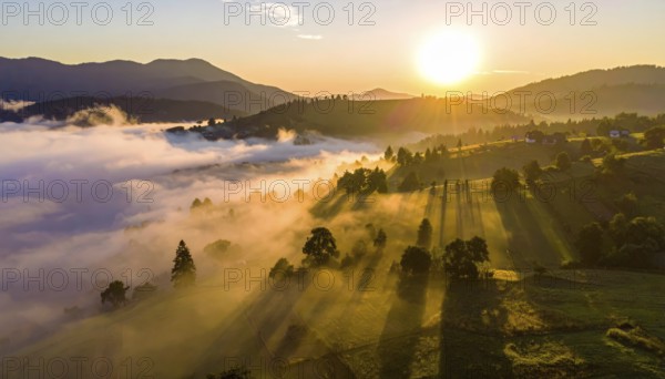 Sunrise over a fog covered village in a rural landscape, golden morning light, serene autumn atmosphere, hills and mountains in the background, AI generated