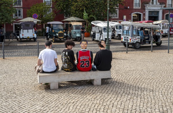 Street art, young people with Ronaldo mask on the back of their heads taking part in a school project about drawing, Lisbon, Portugal