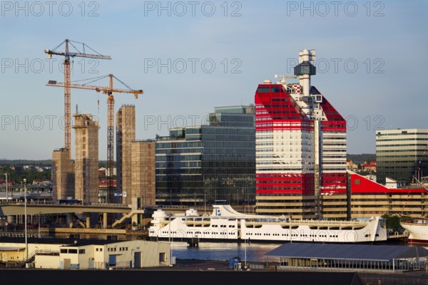 Yellow cranes on construction site of timber building Kaj 16 with hybrid concrete frames, sunny day, Lilla Bommen area on May 13, 2025 in Gothenburg, Sweden