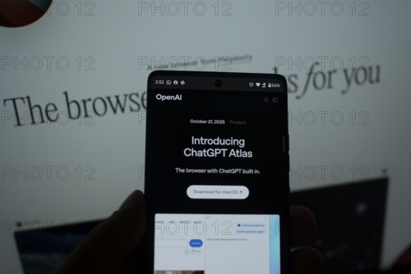 A smartphone displaying a ChatGPT Atlas announcement on its screen