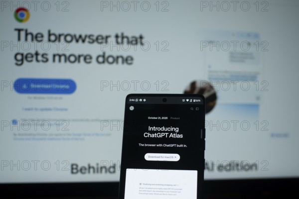 Smartphone showing ChatGPT Atlas with Chrome browser in the background
