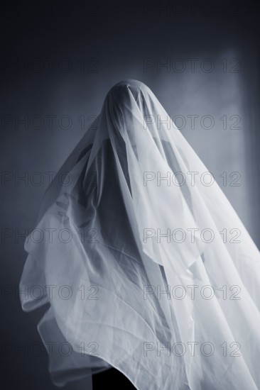 Woman with a white cloth width, ghost costume