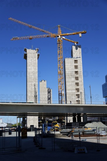 Yellow cranes on construction site of timber building Kaj 16 with hybrid concrete frames, sunny day, Lilla Bommen area on May 12, 2025 in Gothenburg, Sweden
