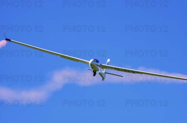 An SZD-59-1 ACRO glider, registration D-1138, during a demonstration as part of an air show at the Fliegerbergfest of the Rossfeld Luftsportverein in Metzingen-Glems, Baden-Württemberg, Germany, for editorial use only