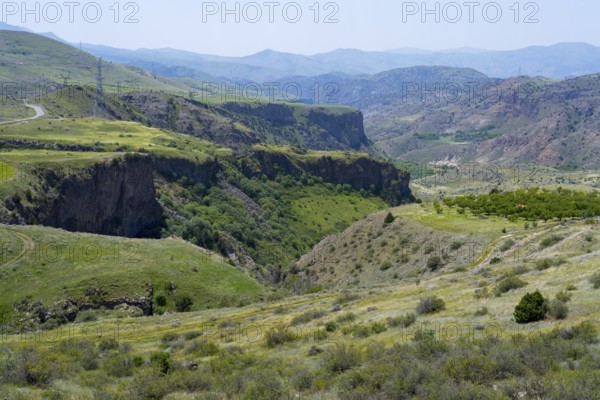 Deep gorge surrounded by green hills and mountains under bright skies, breathtaking scenery south of Jermuk, H42, Vayots Dzor province, Vayots Dzor, Armenia