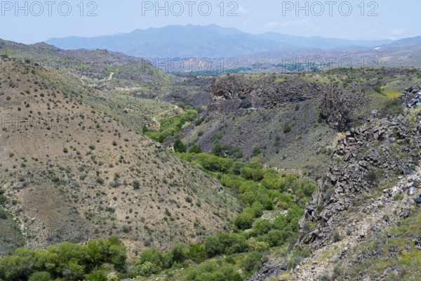 Rocky valley with green trees and distant mountain scenery, Arpa river valley near Vayk, Vayots Dzor province, Wajoz Dzor, Armenia