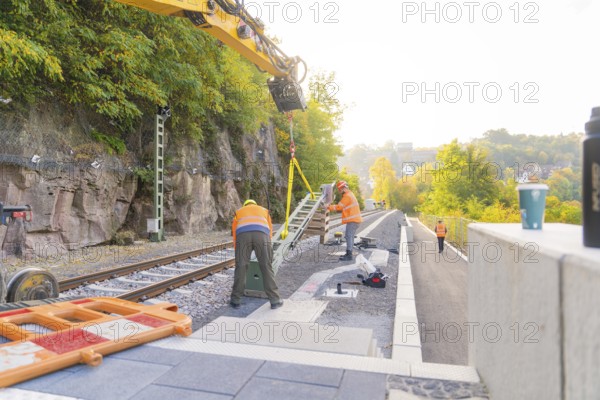 Worker with excavator on railroad tracks, autumnal atmosphere, signal construction at the Hermann Hessebahn, Calw, Germany