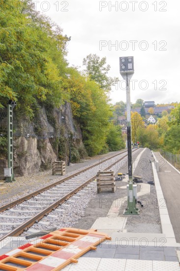 Railway tracks next to rocky embankment and trees, autumn landscape, signal building on the Hermann Hessebahn, Calw, Germany