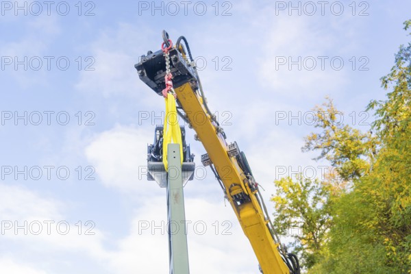 Yellow crane lifts a structure surrounded by trees, blue sky, Signalbau an der Hermann Hessebahn, Calw, Germany