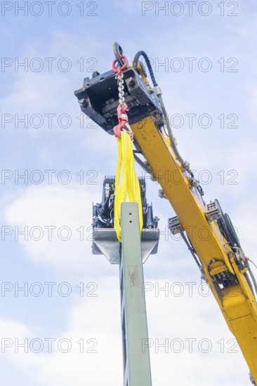 A yellow crane lifts a metal structure, blue sky in the background, signalling at the Hermann Hessebahn, Calw, Germany