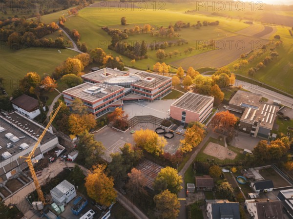 Modern Maria von Linden Gymnasium school building in autumn landscape at sunset, captured by drone, Calw, Black Forest, Germany