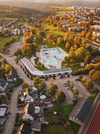 Bird's eye view of swimming pool in the middle of an autumn village, Calw, Black Forest, Germany