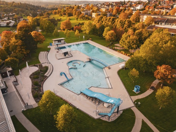 Outdoor pool with empty pool under autumn trees and hilly landscape, Calw, Black Forest, Germany