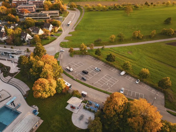 Autumn aerial view of a parking lot with colorful trees and adjacent green spaces, Calw, Black Forest, Germany