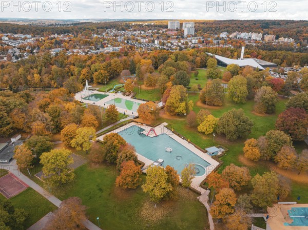 A swimming pool surrounded by autumn trees, nestled in a large park, Sindelfingen, Böblingen district, Germany