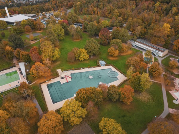 Aerial view of a swimming pool in an autumnal park with colorful trees, Sindelfingen, Böblingen district, Germany