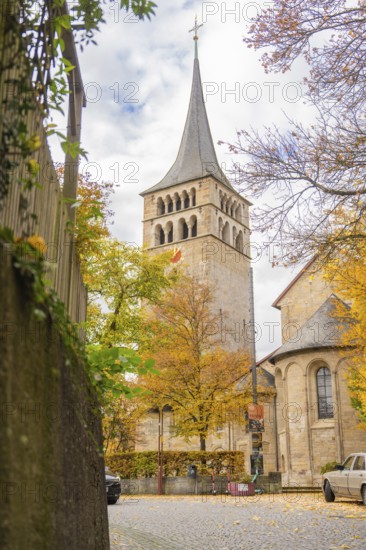 Historic church with high tower surrounded by autumn leaves and cloudy sky, Sindelfingen, Böblingen district, Germany