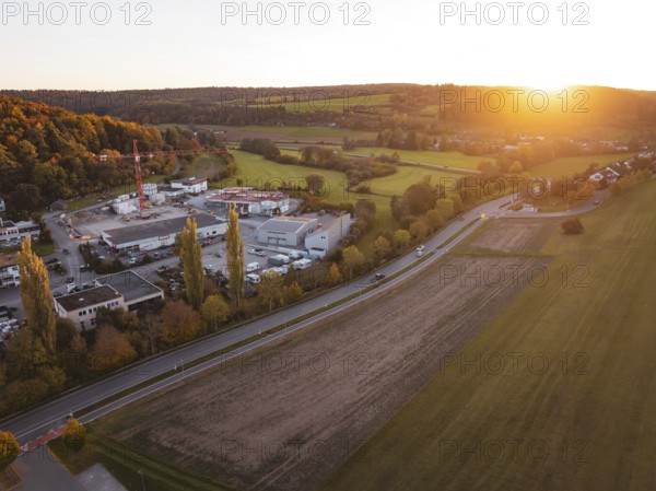 Industrial area at sunset next to fields and road in rural area, Aidlingen, Böblingen district, Germany