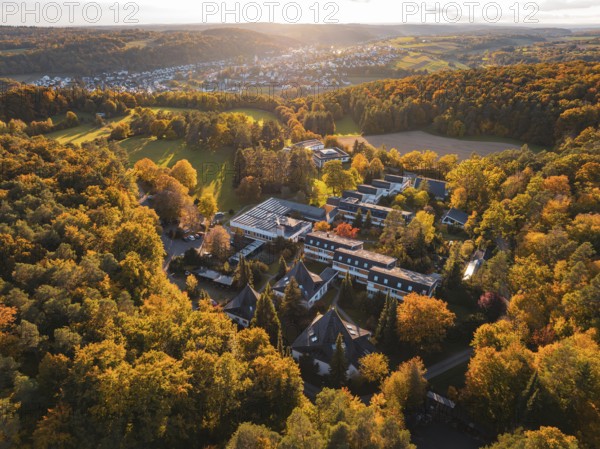 Motherhouse building in autumn landscape with sunset and village in background, Aidlingen, Böblingen district, Germany