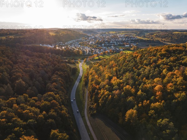 Autumn forest landscape with a road leading to a small settlement, Aidlingen, Böblingen district, Germany