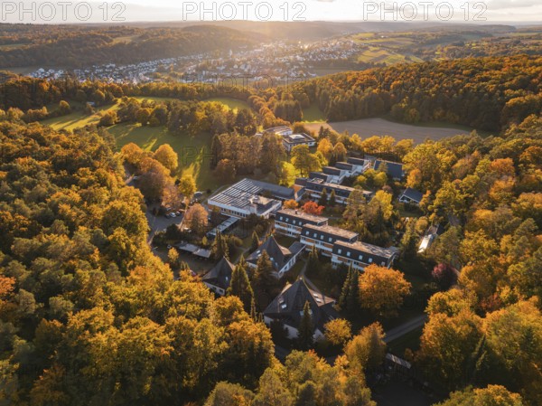 Motherhouse buildings and autumn trees in rural area at sunset, Aidlingen, Böblingen district, Germany
