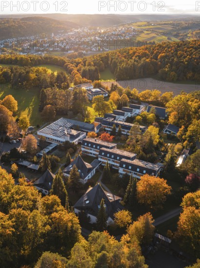 Sunlight illuminates motherhouse buildings and autumn trees in rural surroundings, Aidlingen, Böblingen district, Germany