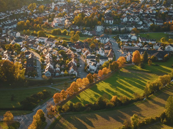 Small town area with autumn-colored trees and illuminated houses, Aidlingen, Böblingen district, Germany
