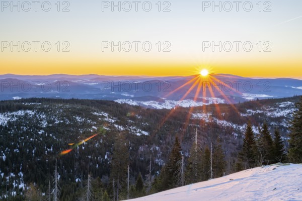 Sunrise over the hills of czech republic from Mount Lusen wth the view over the hills of the bavarian forest in winter, Bavaria, Germany