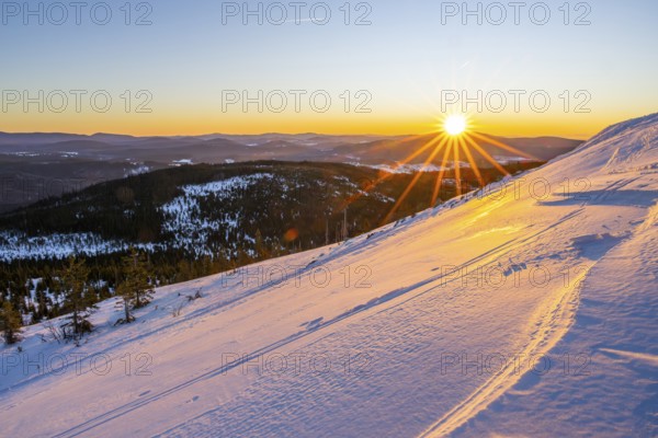 Sunrise over the hills of czech republic from Mount Lusen wth the view over the hills of the bavarian forest in winter, Bavaria, Germany