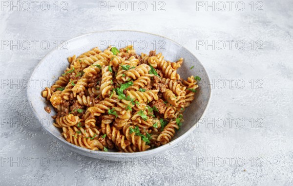 Pasta in navy, pasta with minced meat, gray background, homemade, fusilli pasta, no people
