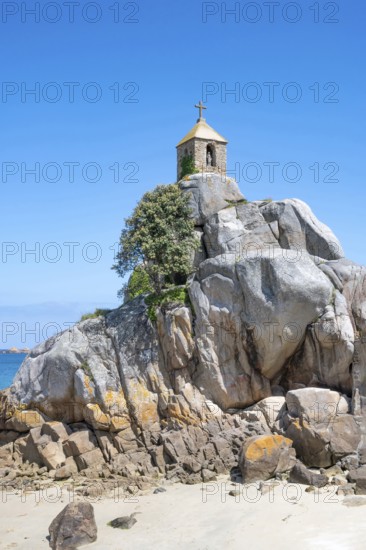 The small, historic Saint-Gildas chapel is perched on rugged, pink rock formations on the banks of a rough pebble and scree beach, from where you can see the Armell Channel and other small, rocky islands, Port Blanc, Penvenan, Cotes-d'Armor department, Brittany region, France
