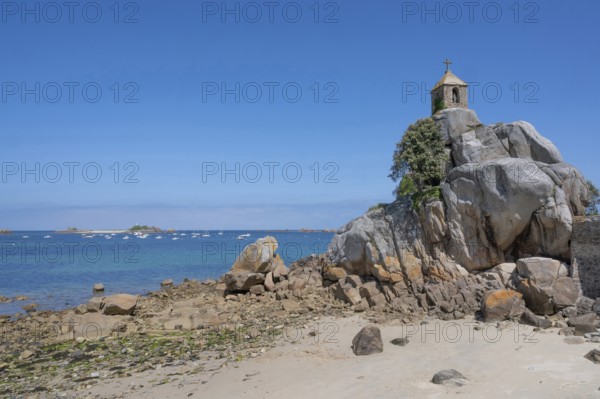 The small, historic Saint-Gildas chapel is perched on rugged, pink rock formations on the banks of a rough pebble and scree beach, from where you can see the Armell Channel and other small, rocky islands, Port Blanc, Penvenan, Cotes-d'Armor department, Brittany region, France