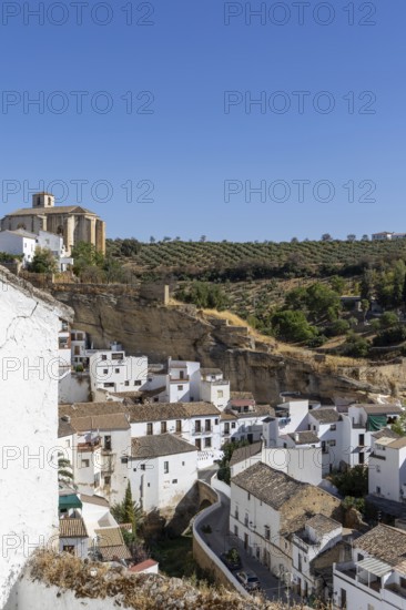 On the road to the white villages. Panorama or skyline of a historic old town with many white houses built on and in the mountain. Setenil de las Bodegas, Andalusia, Spain