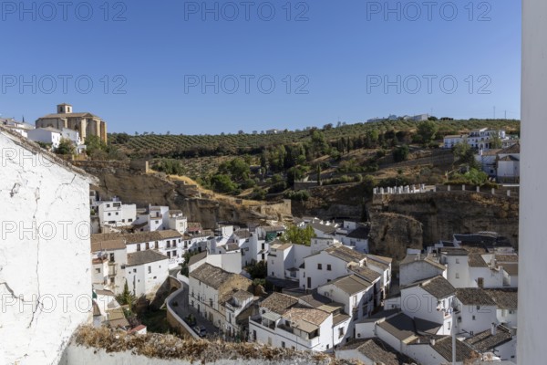 On the road to the white villages. Panorama or skyline of a historic old town with many white houses built on and in the mountain. Setenil de las Bodegas, Andalusia, Spain