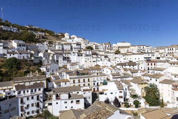 On the road to the white villages. Panorama or skyline of a historic old town with many white houses built on and in the mountain. Setenil de las Bodegas, Andalusia, Spain