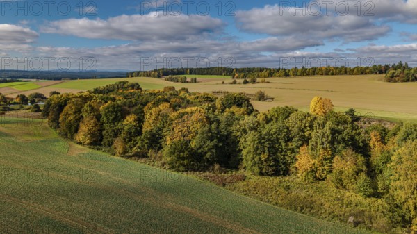 In this rural area, autumn trees of various colors can be seen. The rolling hills and clear skies give the scene a peaceful atmosphere. Bad Neualbenreuth, Upper Palatinate