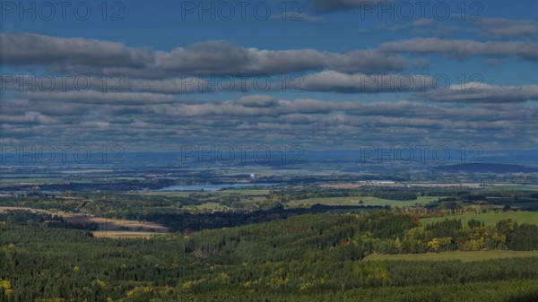 The picture shows a picturesque landscape with green forests, rolling hills and a river in the background. The sky is covered with beautiful clouds. Cheb, Czech Republic
