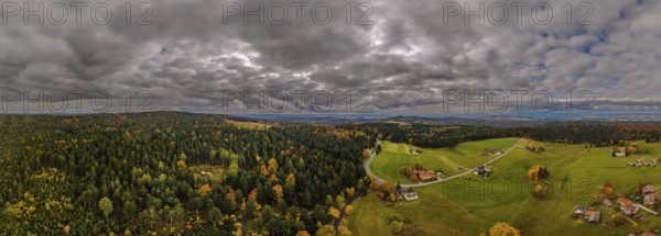 In Upper Palatinate, the autumn landscape features colorful trees and a gentle hilly landscape. Grey clouds move across the vastness of the sky. Nature presents itself in full splendor. Altglashütte, Upper Palatinate
