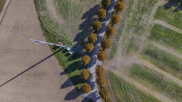 A hiking trail runs next to a field, lined with trees, while an antenna pole stands in the background. The clear sky shows a beautiful day outdoors. Bad Neualbenreuth, Upper Palatinate