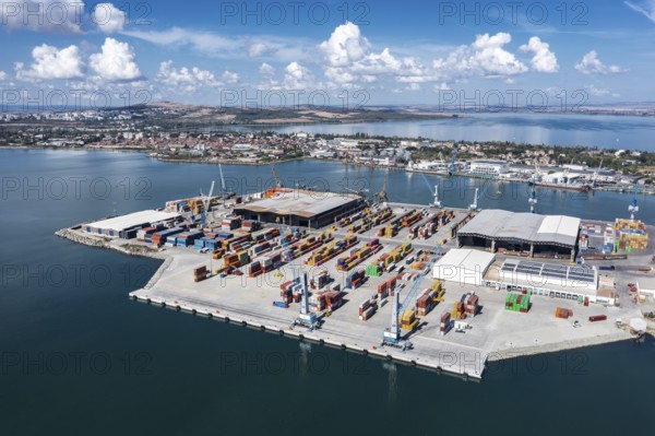 A busy port with shipping containers and cranes. Aerial view to new container unloading terminal of port of Burgas, Bulgaria. Logistics and transport
