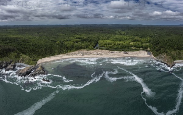 Panoramic view of a beach with crashing waves and dense forests. Aerial view to beautiful Silistar beach near to Sinemorec, Burgas, Bulgaria